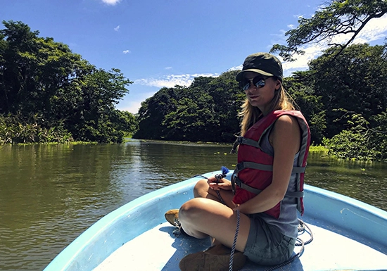 Pink dolphin watching in Iquitos — rare Amazon pink river dolphin surfacing near a tour boat in murky river waters